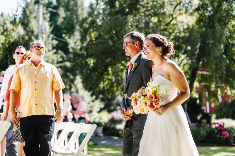 Bride walking down the aisle with her father at an outdoor ceremony