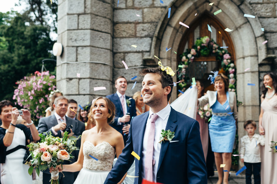 Bride and groom walking happily through confetti at Crinken Church in Bray, Ireland